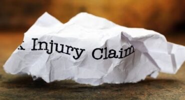 Injury claim form wadded up on a desk.