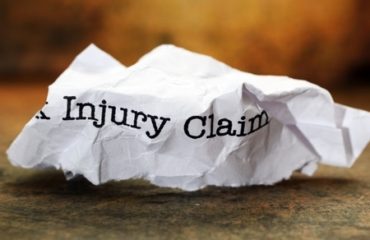 Injury claim form wadded up on a desk.