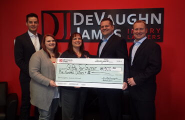 Richard James and Dustin DeVaughn presenting a check to the latest WINS for Kansas recipient.