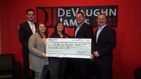 Richard James and Dustin DeVaughn presenting a check to the latest WINS for Kansas recipient.