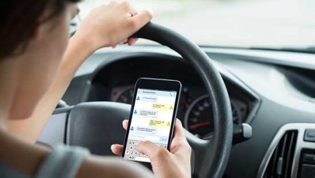 Driver holding and looking at cell phone while driving.