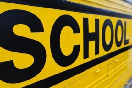 Very close image of the side of a school bus in a school zone.