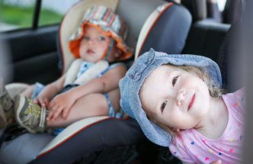 Young children in car seats in back of vehicle