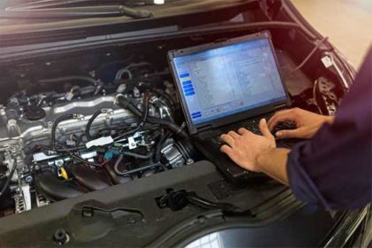 Car technician checking car data recorder