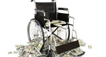 Wheelchair with pile of money indicating high medical costs