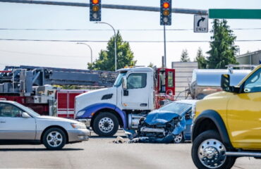 Semi-truck and Car collide in busy intersection.