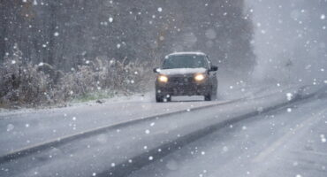 Car driving on Kansas winter road in snowy conditions.