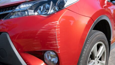 Single red sedan with damaged bumper. Red sedan with damaged front bumper.