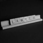 Wooden game tiles with the letters that spell Lawyer.